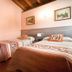 Hotel Rural Las Palmeras Muskiz twin room with two single beds, wood ceiling, and framed wall art
