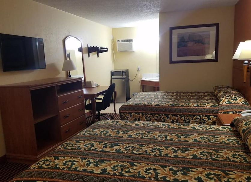 Budget Inn Keokuk room with two double beds, TV, desk, and lamp