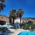 Dolphin Hotel in Skopelos with outdoor pool, sun loungers, palm trees and hillside buildings