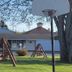 Mackinaw Budget Inn in Mackinaw City with a courtyard basketball hoop, trees, and motel buildings