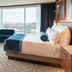 Resorts World Catskills room in Monticello with king bed, teal seating, and large windows with scenic views