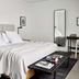 Bluebird Spa City Motor Lodge in Saratoga Springs bedroom with a king bed, desk, mirror and bench
