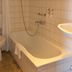 Fletcher Badhotel Egmond aan Zee bathroom with bathtub, shower and tiled walls in Egmond aan Zee
