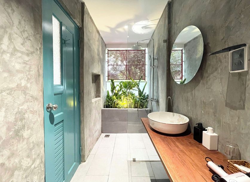 Diamond Star Hotel in Vung Tau bathroom with freestanding sink, wood vanity, turquoise door and garden view