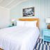 Surf House in Hampton guest room with white bed, blue nightstands and striped rug