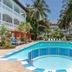 Sarges Hotel in Serrekunda: tropical courtyard pool with palms, lounge chairs, and multi-story balconies