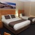 Dongara Hotel Motel room with two beds, bedside lamps, wall art, and a floor mirror in Dongara