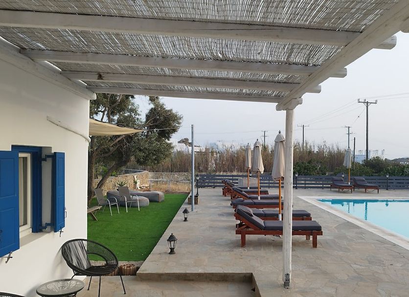 Nikos Rooms in Ornos with poolside loungers and shaded terrace beside the outdoor pool