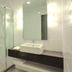 Hotel Glodok Plaza in Jakarta bathroom with glass shower, wall-mounted sink and toilet