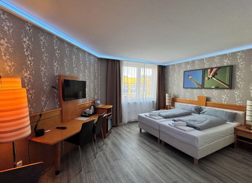 Parkhotel Viktoria in Velten guest room with double bed, desk, TV, and floor-to-ceiling window