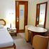 Hotel Grão Para room in Belém with double bed, bedside lamp, round table, and mirror