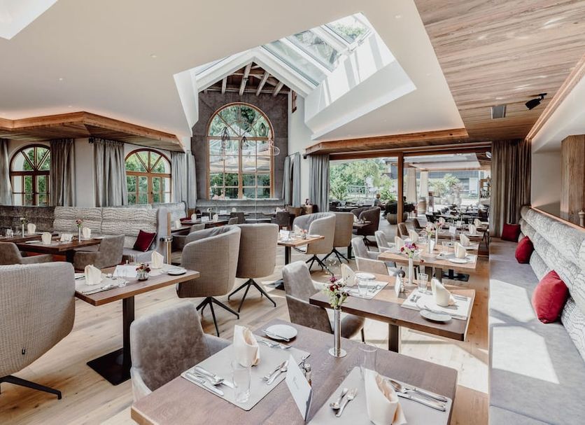 Hotel Elisabeth in Kirchberg in Tirol dining room with large arched windows and set tables