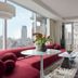 Hotel Park Ave Nyc in New York suite with red curved sofa, city view, and balcony access