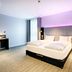 Premier Inn Lübeck City Centre room with king bed, desk, and soft purple lighting in Lübeck