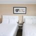 Bryce Uptop Lodge in Bryce: two white beds in a simple hotel room with beige walls and framed art