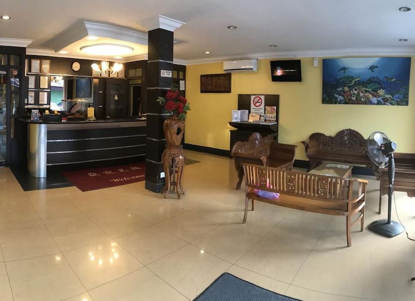 Sipadan Inn 1, Semporna lobby with front desk, seating area, wall art and standing fan