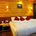 Hotel Jagjeet, Darjeeling: cozy wood-paneled guest room with king bed and red accent pillows