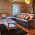 Le Clos Loret in Saint-Germain-du-Corbéis: rustic lounge with stone walls, sectional sofa and coffee table