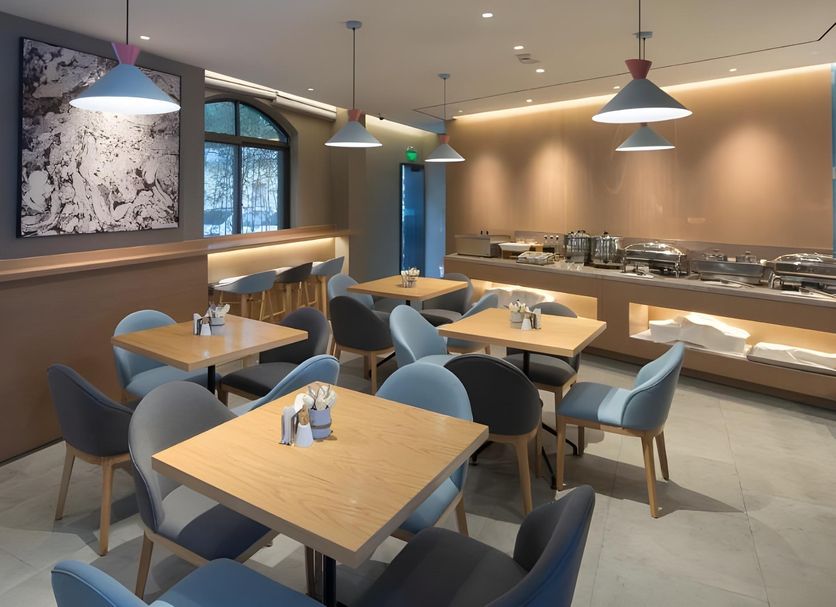 Home Inn Dalian Jinzhou Railway Station Stadium restaurant with tables, blue chairs, and buffet counter