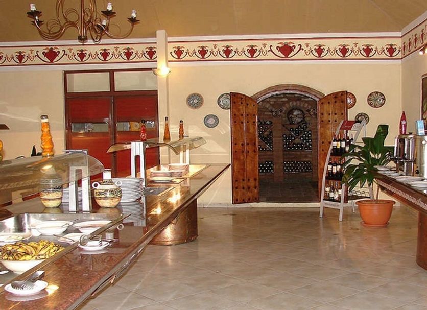Cubanacan Las Cuevas in Trinidad, buffet dining room with covered food stations and arched wooden doors