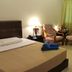Crystal Hill R in Ranau guest room with bed, sofa, chairs, lamp and curtained window