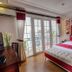 La Beaute De Hanoi Hotel guest room with red accents, balcony doors, and city view in Hanoi