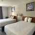 Motel 6 - Laurel, MS guest room with two double beds, wall art, and bedside lamps