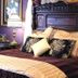 Hearthstone Elegant Lodge by the River in Kamiah: ornate king bed with carved headboard and floral pillows
