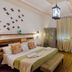 Domatia Barletta room with double bed, wooden wardrobe, desk, and butterfly wall decor