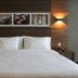 Hilton Garden Inn Aguascalientes guest room with king bed, wood-paneled walls, and bedside lamps