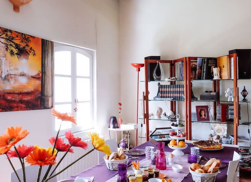 La Villa Des Violettes in Toulouse: colorful dining room with set table, floral decor, and bright window