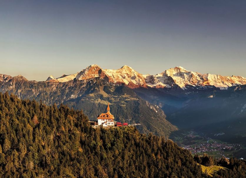 Hotel Alpenblick in Wilderswil with mountain views and a hillside hotel surrounded by forest