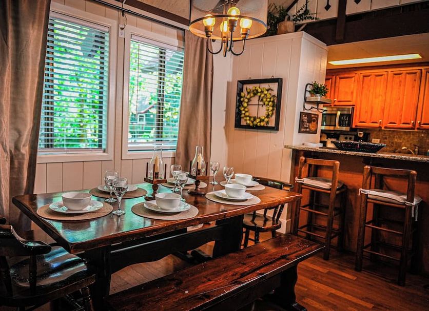 Pine Mountain Club Chalets Resort dining room with set table, wood benches, and kitchen bar in Pine Mountain