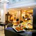 Pestana Curitiba hotel buffet dining area with tables, chairs, and plated food in Curitiba