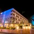 La'gent Hotel Okinawa Chatan at night with blue-lit facade, palm trees, and entrance landscaping in Chatan
