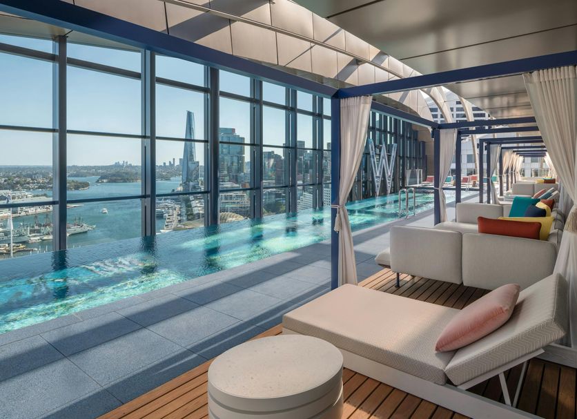 W Sydney rooftop infinity pool with city and harbor views, plus cabana loungers and daybeds