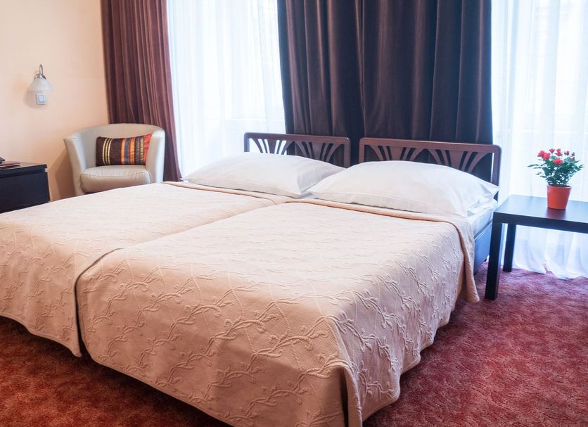 Hotel Bajazzo Vienna guest room with double bed, armchair, table lamp and dark curtains