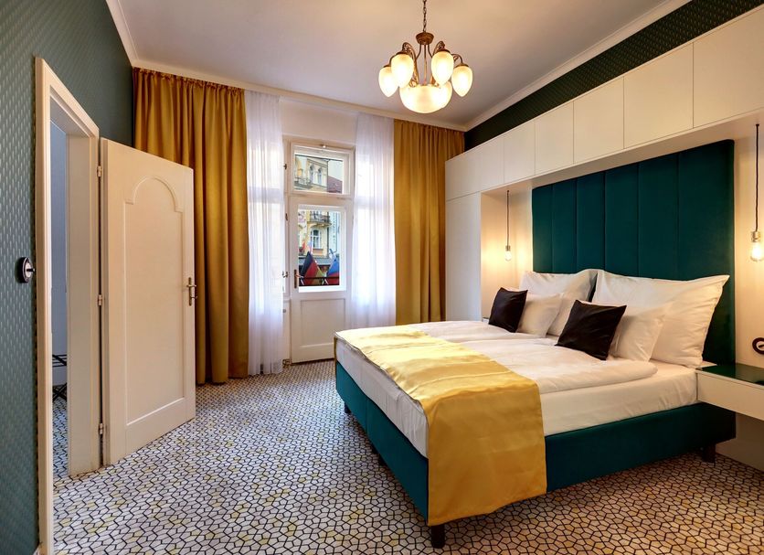 Art Deco Wolker By Astoria Hotel & Medical Spa in Carlsbad bedroom with teal headboard and gold curtains