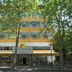 Hotel & Residence Parador in Cesenatico, yellow facade with balconies behind trees