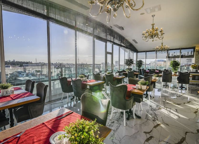 Dining area at Sveo Business Hotel in Ankara with floor-to-ceiling windows and city views