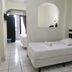 Hotel Armonía Hostal room in San Salvador with twin beds, tiled floor and arched wall niche