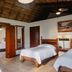 Villa Blanca Cloud Forest Hotel + Retreat in San Ramón guest room with three beds and wood ceiling