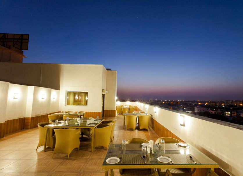 Ginger Jaipur rooftop terrace dining area with city lights at dusk in Jaipur