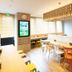 Super Hotel Okinawa Nago breakfast area with communal tables, chairs, and a bright modern interior