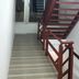 Ideal Hotel Pratunam in Bangkok stairwell with red stairs and a window view of an interior landing