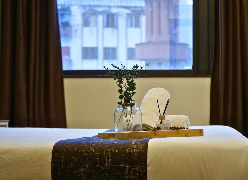 Myciti Hotel Kuala Lumpur guest room bed with tray, vase, towels, and city view in Kuala Lumpur