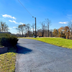 Red Carpet Inn & Suites Morgantown driveway entrance with grassy slope and roadside sign