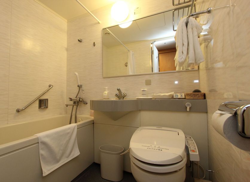 Hotel Mielparque Kumamoto bathroom with bathtub, toilet, sink, mirror, and hanging towels