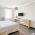 Appart'City Classic Reims Parc des Expositions guest room with bed, desk, TV and window in Reims