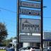 Hole Inn the Wall Hotel - Fort Walton Beach - Sunset Plaza sign near Bowler Kingdom and a palm tree